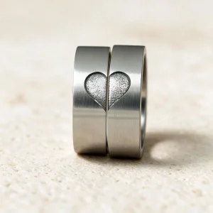 Alianzas acero Alba — par de alianzas de acero de 7 mm con un corazón partido que se une, hecho a mano en el taller de Barcelona